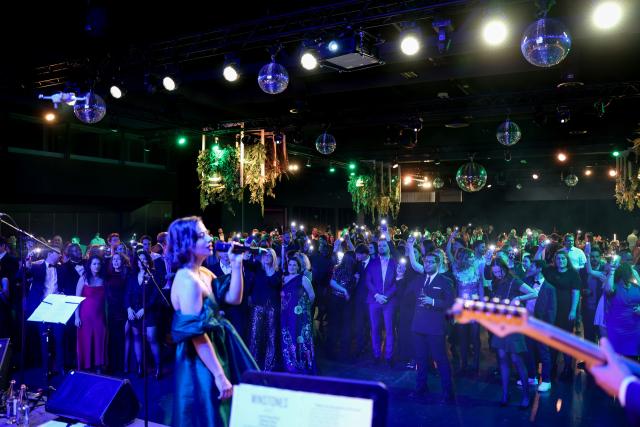 A woman from Elvinger Hoss Prussen singing in front of lots of people