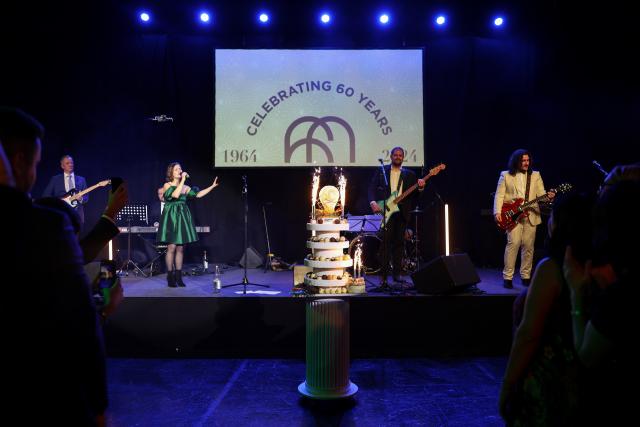 Elvinger Hoss Prussen band in front of a birthday cake