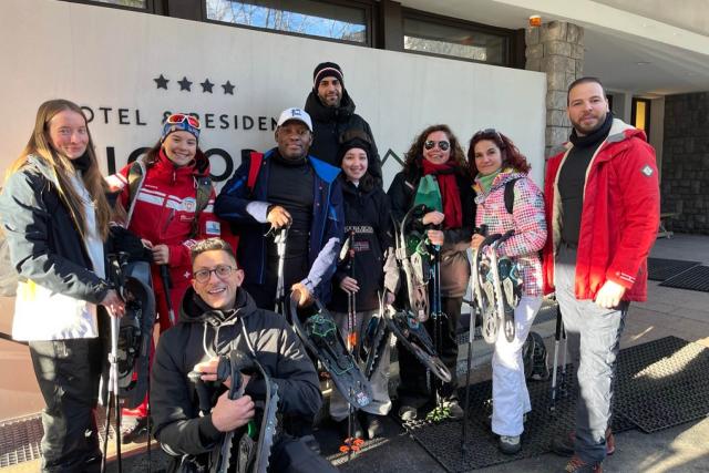 Group picture in front of the hotel with snowshoe equipment